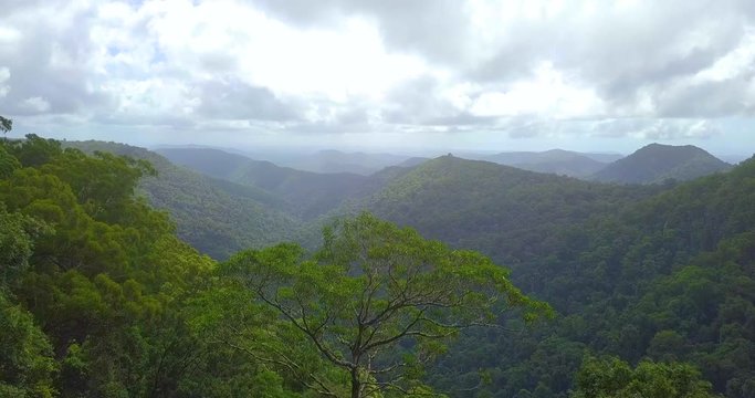 Aerial of green mountain ranges on a cloudy day.