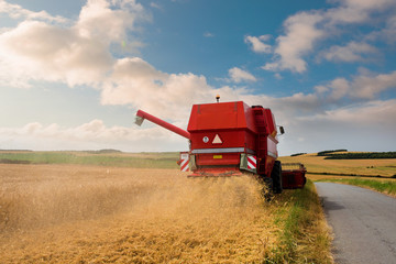 beautiful landscape with a combine harvester in action
