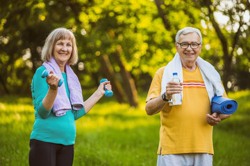Happy senior couple is ready for exercising in park. 