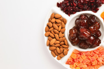 Mix of dried fruits and nuts. Apricot, raisin, cranberry, dates fruit. Isolated on a white background. Space for text or design.
