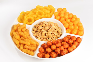 Mix of snacks on a white plate isolated on white.