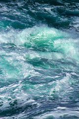 Aquatic background of sea surf waves splashing close up with clear blue green water and white foam