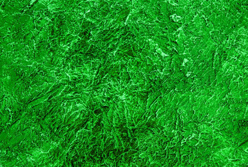 The texture of the plaster on the wall is painted in a  green color. Background.	