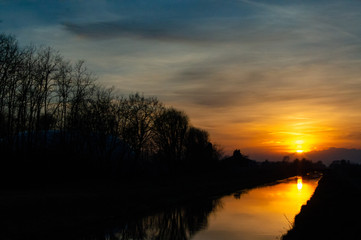 nature sunset in Italy close up to river with reflection