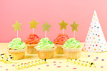Kids birthday party accessories - colorful cupcakes, party hat, streamers, confetti. Copy space