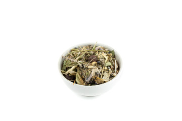 Dry herbal tea mix in ceramic bowl isolated on white