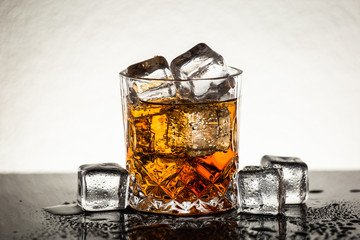 Whiskey glass with ice cubes. Alcohol shot beverage.