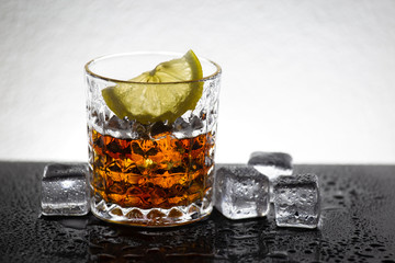 Glass of cocktail with lemon slice. Alcohol beverage art. Cold water and ice cube. Ingredient mixer beverage.