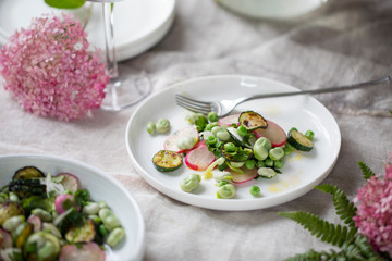 Fresh garden salad with broad beans, green peas, radishes and courgette