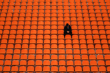 lonely man on the empty stadium seat cheering for the team, one man army concept