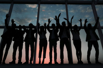 silhouette of a group of business people raising their hand