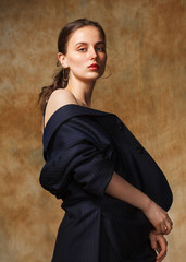sensual fashion studio portrait of young brunette woman on beige background