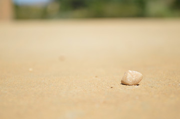 Fototapeta na wymiar Single Stone on a White Sandy Road in the Middle of Nowhere