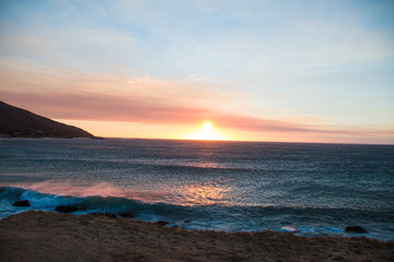 Obraz premium Chapman's Peak Drive Through the Mountains in Cape Town at Sunset Next to the Sea with Crashing Waves in South Africa