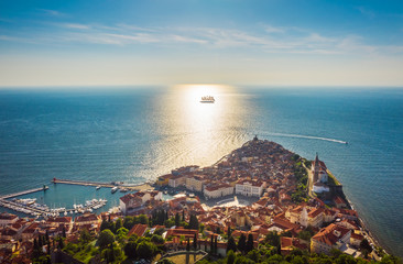 Aerial view of the old city Piran and beautiful sailing ship with five masts at sunset time....