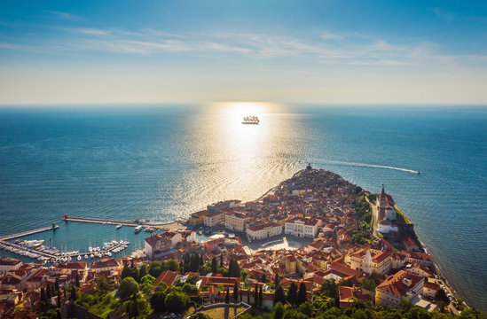 Aerial view of the old city Piran and beautiful sailing ship with five masts at sunset time. Slovenia, Europe