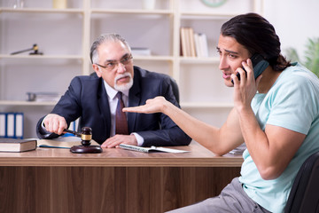 Young man visiting experienced male lawyer 