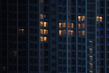 Fototapeta na wymiar construction workers building on an interior decoration of a big apartment high rise modern skyscraper. working overtime on a development project during night time.