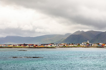 Fototapeta premium Andenes village panorama with multiple houses and mountains in the background, Lofoten islands, Andoy Municipality, Vesteralen district, Nordland county, Norway