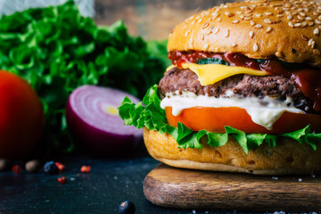 Home made Burger (cheeseburger) with beef on a wooden background. Classic home made Burger. Close up, copy space.