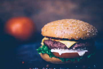 Home made Burger (cheeseburger) with beef on a wooden background. Classic home made Burger. Close up, copy space.