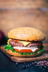 Home made Burger (cheeseburger) with beef on a wooden background. Classic home made Burger. Close up, copy space.