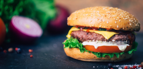 Home made Burger (cheeseburger) with beef on a wooden background. Classic home made Burger. Close up, copy space.