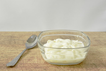 fruit yogurt in glass bowl and silver spoon on table