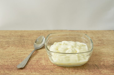 fruit yogurt in glass bowl and silver spoon on table