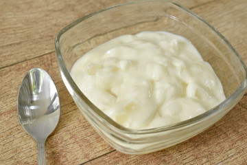 fruit yogurt in glass bowl and silver spoon on table