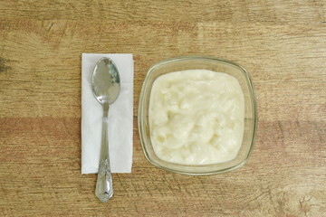 fruit yogurt in glass bowl and silver spoon on tissue paper