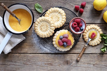 Lemon tartlets with lemon curd and fresh berries. Overhead view