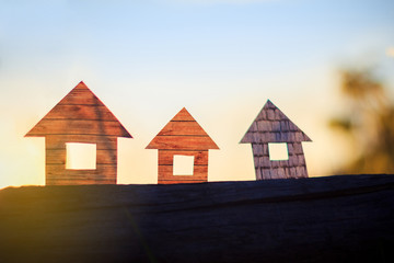 Conceptual paper houses isolated on the sunset sky