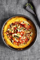 Polenta bake with vegetables and feta cheese. Overhead view. Copy space