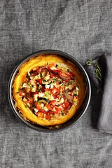 Polenta bake with vegetables and feta cheese. Overhead view. Copy space