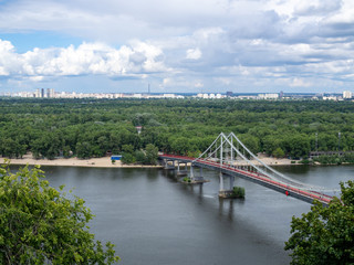 Aerial view of the Pedestrian bridge over the Dnieper river in the centre of Kiev, Ukraine, cloudy sky