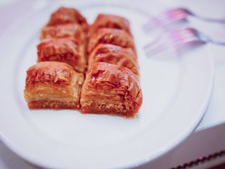 Sweet Turkish baklava on a plate with forks on the side