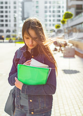 Back to school student teenager girl holding books and note books wearing backpack. Outdoor portrait of young teenager brunette girl with long hair. girl on city