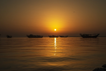 Fototapeta na wymiar Beautiful Sunrise Boat in seaside with yellow and dark sky. Dammam -Saudi Arabia