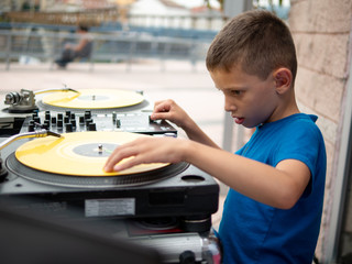 boy (6-8) mixing record on turntable