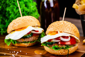 Tasty burgers with chips served on cutting board