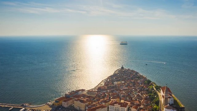 4K. Flight over old city Piran and beautiful sailing ship with five masts. Time Lapse video at sunset time. Slovenia, Europe.