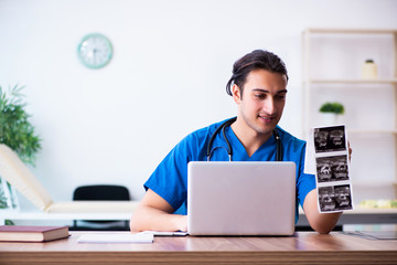 Young male doctor looking at doppler images