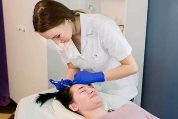 Obraz premium Hair beauty, mesotherapy: a beautician trichologist doctor. Needle mesotherapy. Cosmetic been injected in woman's head. strengthen the hair and their growth