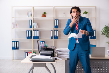 Young employee making copies at copying machine 