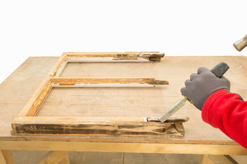 Carpenter using a chisel while repairing an old window sash