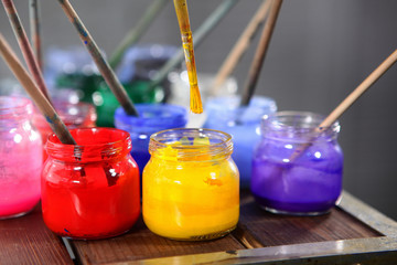 Varied colors of paints for painting in jars close up. The range of colors. Concept hobbies and...
