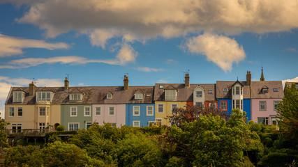 Fototapeta na wymiar Colourful English houses in English seaside town with blue sky and fluffy white clouds 
