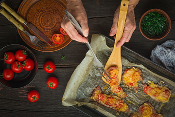 Woman cooked meat baked with sauce and cheese