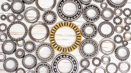 Bearings of all kinds and classifications on a white wooden background.